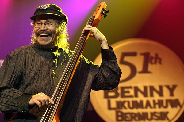 Benny Likumahuwa tersenyum sambil memetik senar bass di atas panggung